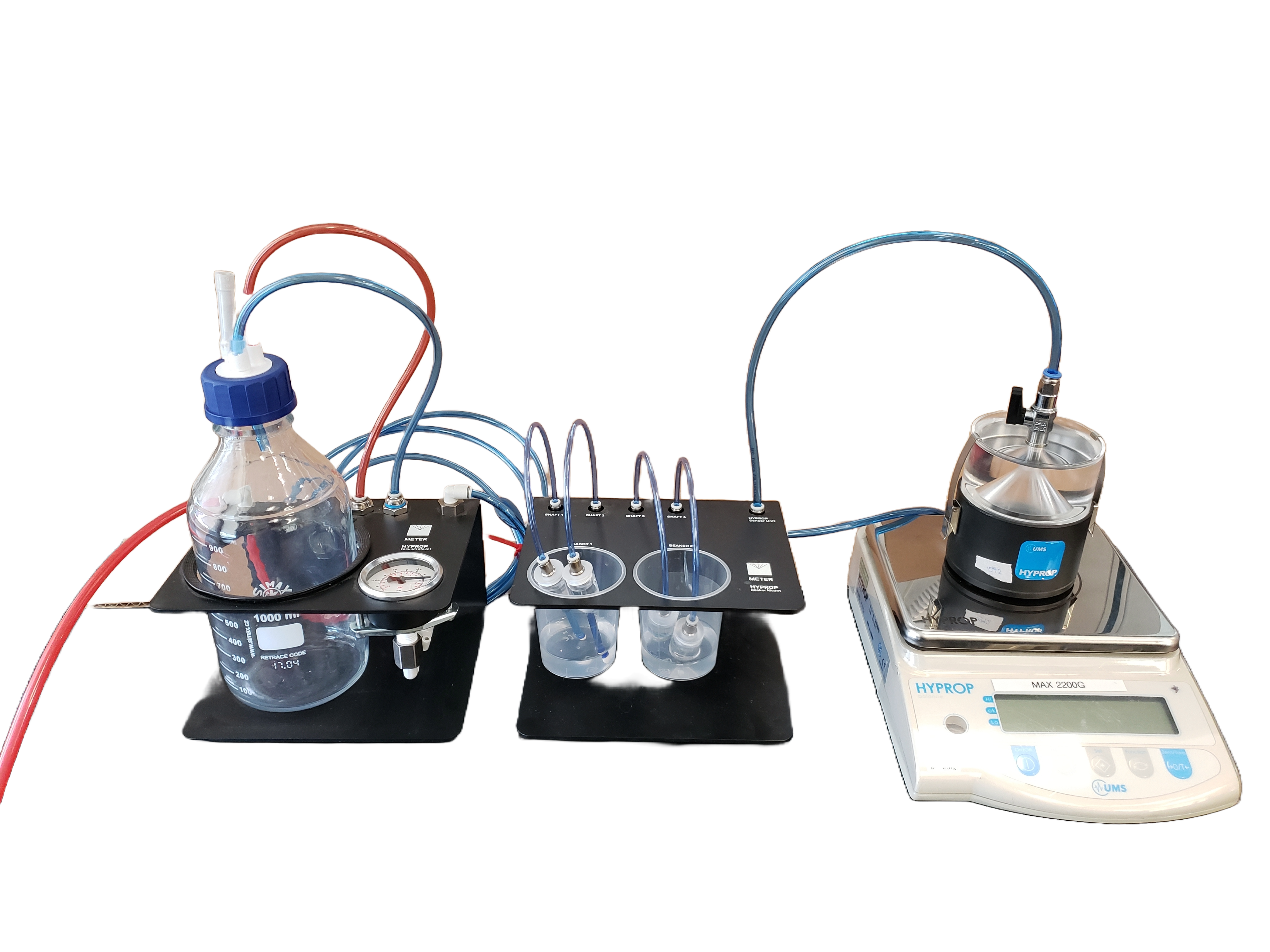 A configuration of vacuum pipes, sensors, lab glassware, and a scale.